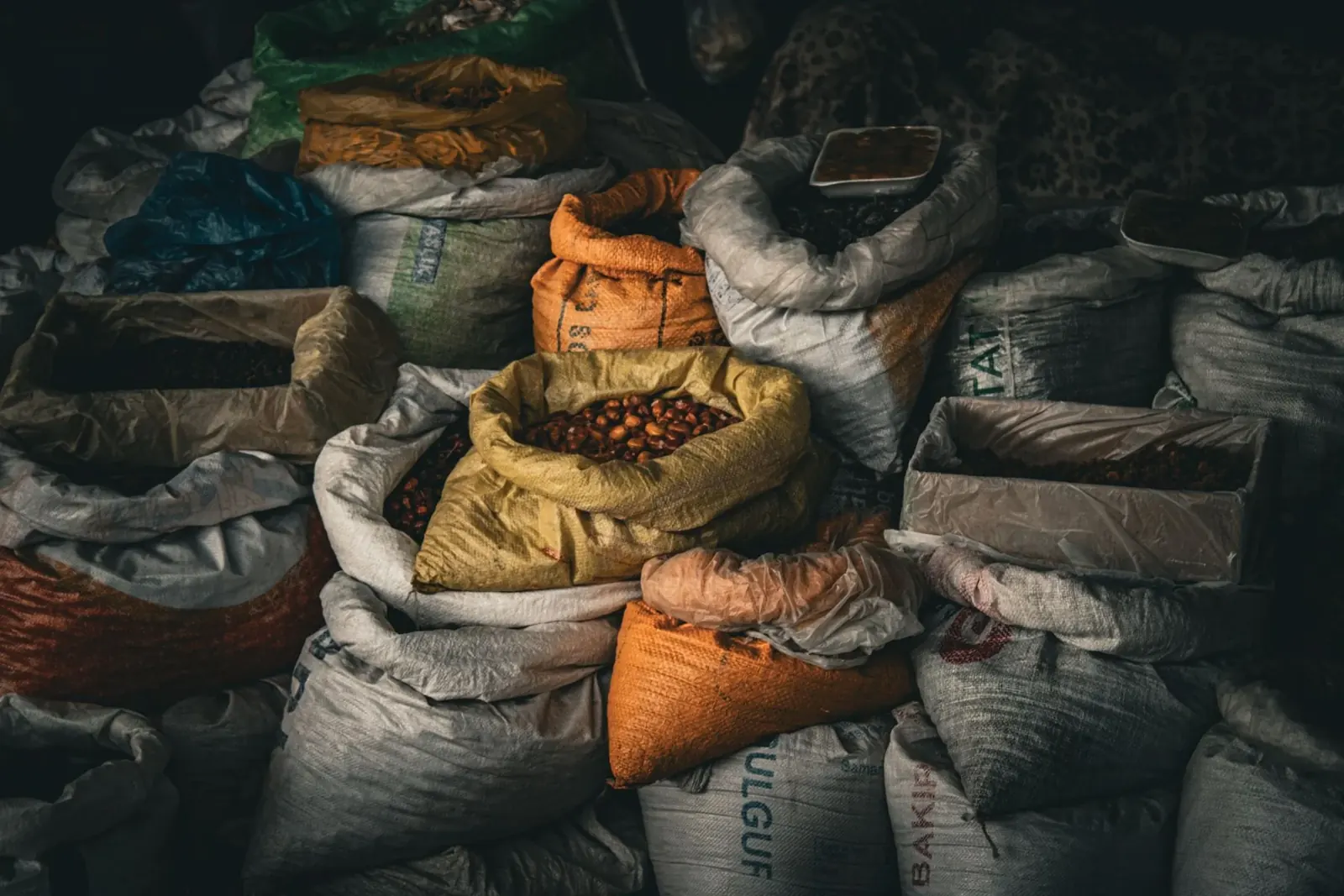 Sacks of colourful grains and whole spices at a wholesale market