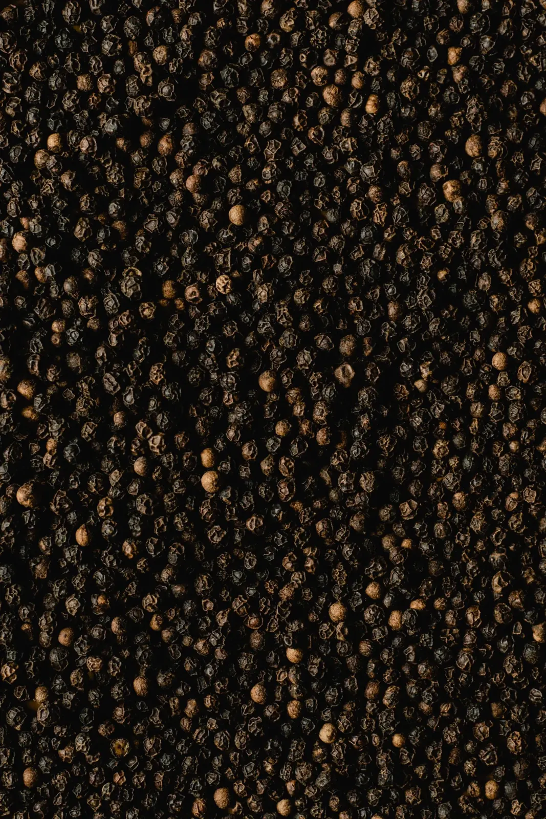 Whole black peppercorns in rich macro detail